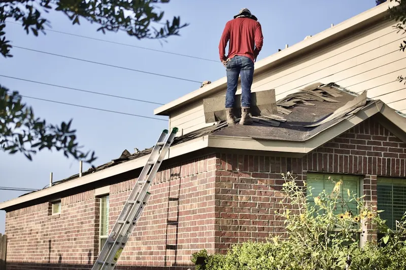 Professional roofer working on a residential roof in Barnstable Town
